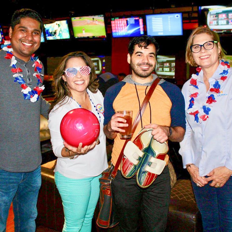 A few people at a bowling alley will red, white, and blue decorations.