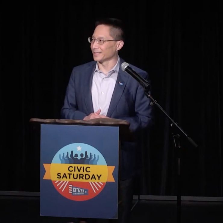 Eric Liu standing at a Civic Saturday podium and speaking.