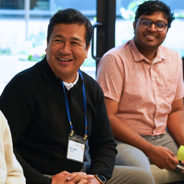 Three people sitting and smiling together.