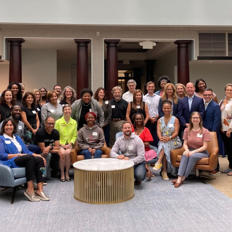 A large group standing in a lobby smiling for a photo.