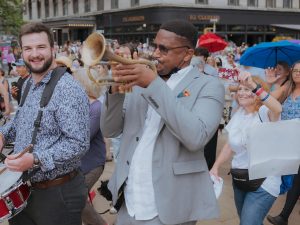 People marching in a parade and playing instruments.