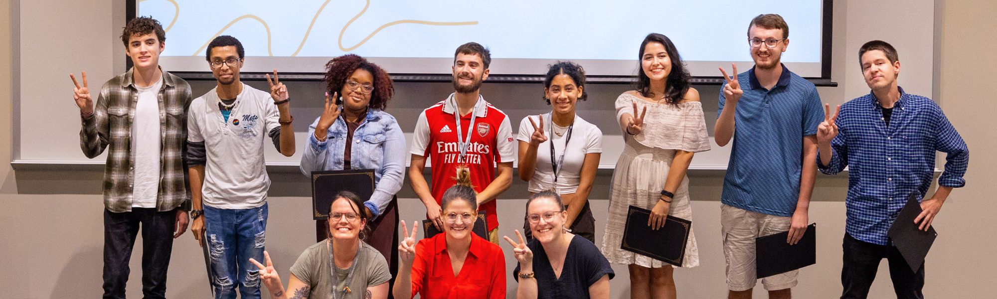 Students standing at the front of a classroom.