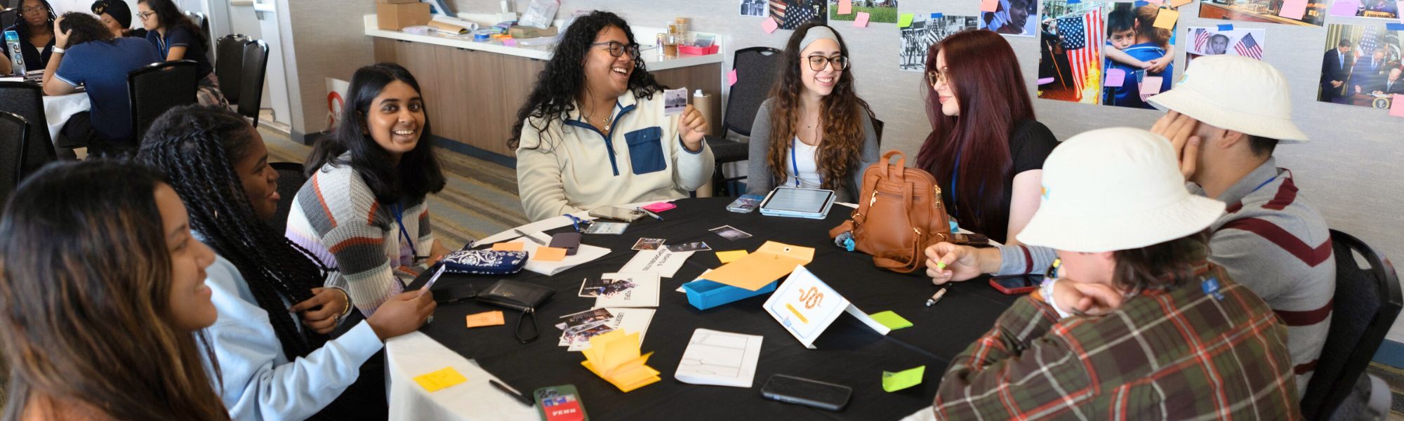 A group of students sitting around a table with papers in front of them.